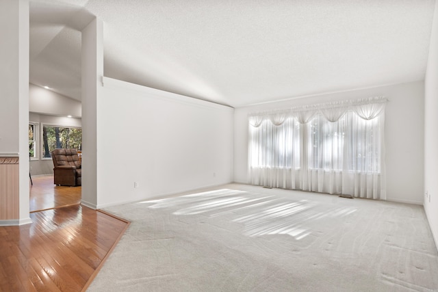 unfurnished room with a textured ceiling and wood finished floors