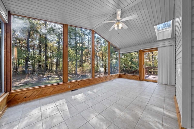 unfurnished sunroom featuring visible vents, vaulted ceiling with skylight, and ceiling fan