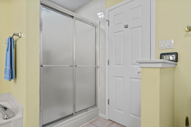 full bath with tile patterned floors, a shower stall, and a garden tub