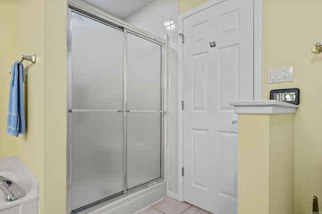 full bathroom with tile patterned floors, a shower stall, and a bath
