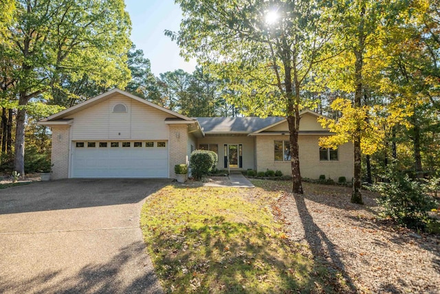 ranch-style house featuring a garage, brick siding, and driveway