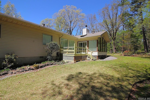 back of house with a sunroom, crawl space, a yard, and a chimney