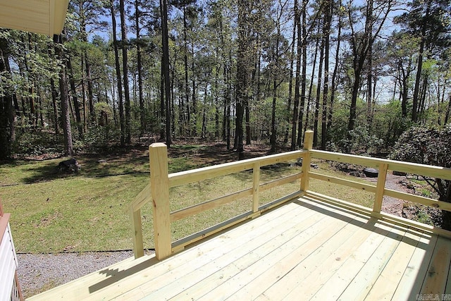 wooden deck featuring a lawn