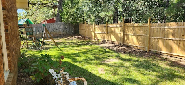 view of yard with a playground and a fenced backyard