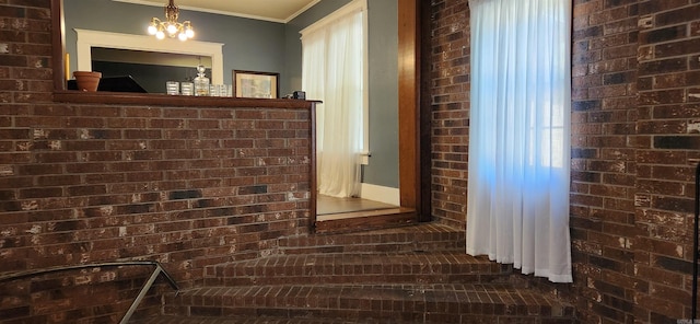 details featuring ornamental molding and an inviting chandelier