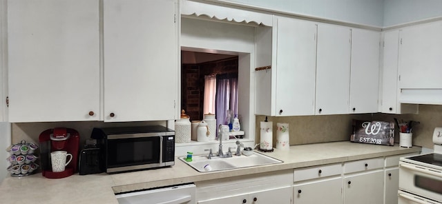 kitchen featuring white appliances, white cabinetry, and sink