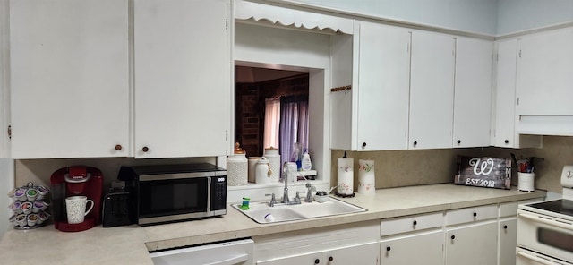 kitchen featuring stainless steel microwave, double oven range, dishwasher, light countertops, and a sink