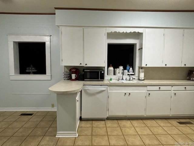 kitchen with stainless steel microwave, light countertops, light tile patterned floors, white dishwasher, and a sink