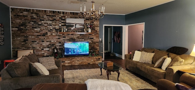 living room featuring a textured ceiling, ornamental molding, hardwood / wood-style floors, and a chandelier