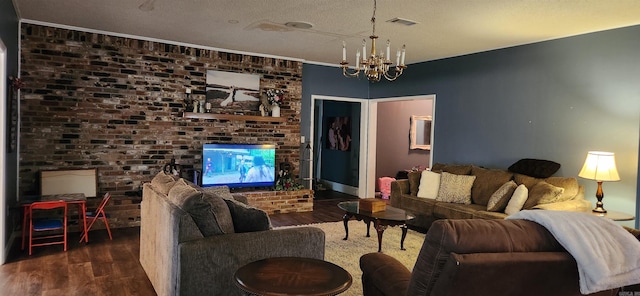 living room featuring a fireplace, ornamental molding, a textured ceiling, a chandelier, and dark wood-type flooring