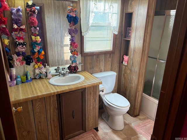 bathroom featuring vanity, toilet, wood walls, and tile patterned floors