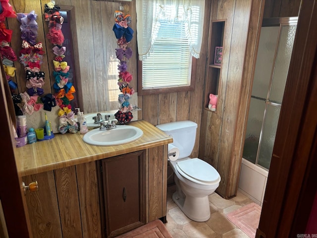 bathroom featuring vanity, toilet, wood walls, and enclosed tub / shower combo