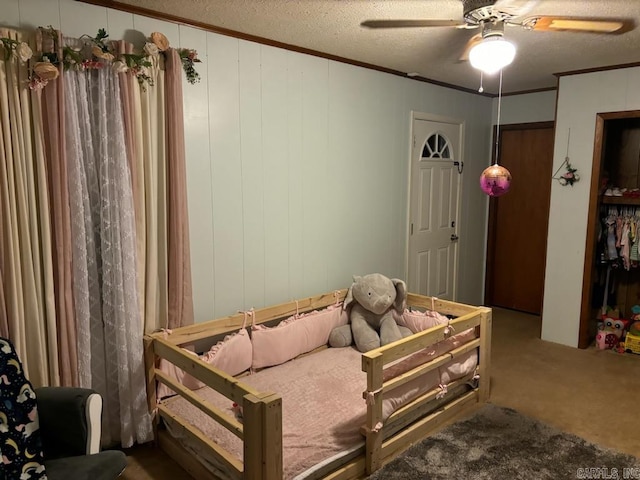 carpeted bedroom featuring a textured ceiling, ceiling fan, and ornamental molding