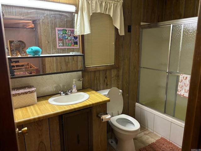 full bathroom with shower / bath combination with glass door, tile patterned flooring, toilet, and vanity