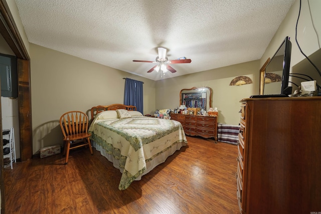 bedroom with a textured ceiling, ceiling fan, and dark hardwood / wood-style flooring