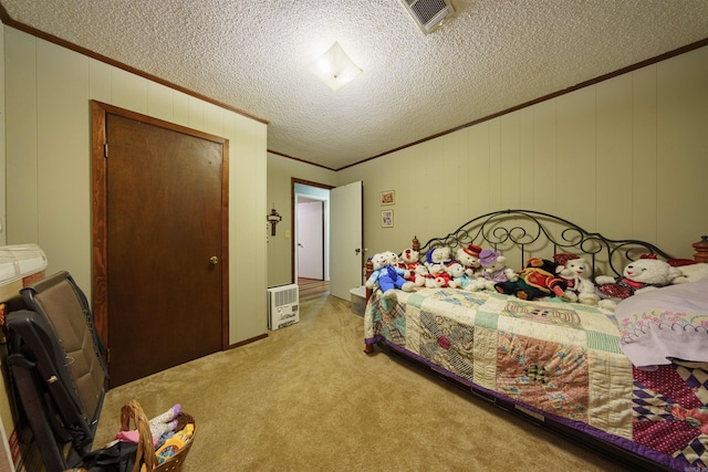 carpeted bedroom with ornamental molding and a textured ceiling