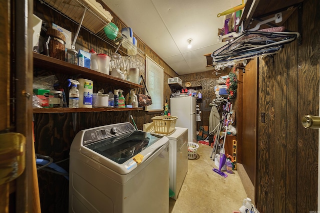 basement featuring washer and dryer and white fridge