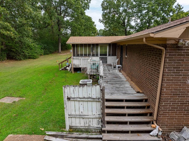 view of front of home featuring a wooden deck, a front yard, and a sunroom