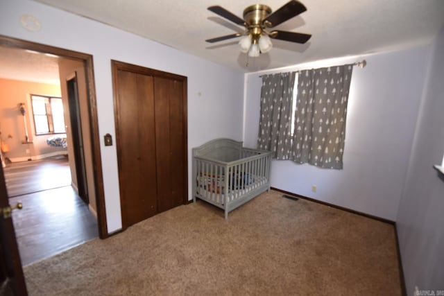 unfurnished bedroom with ceiling fan, a closet, and carpet floors