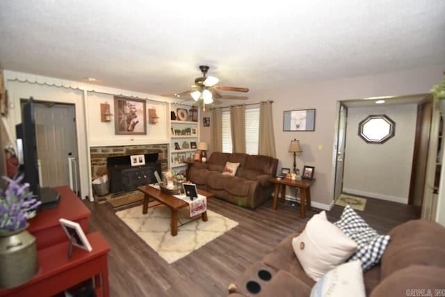 living room with built in features, dark hardwood / wood-style flooring, a wood stove, and plenty of natural light