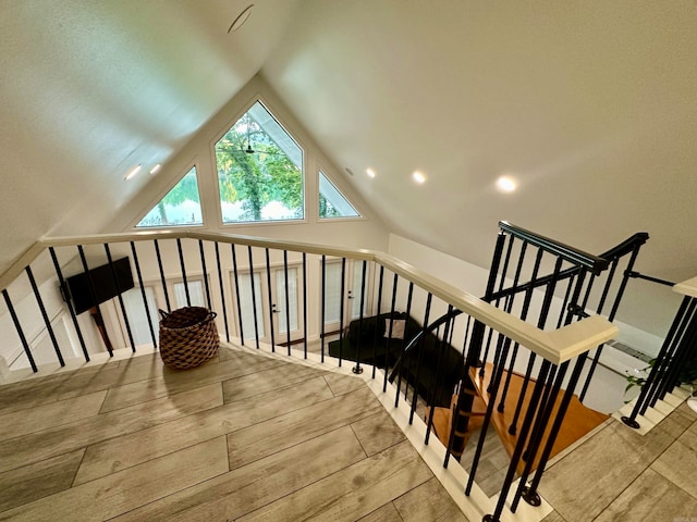 additional living space featuring light hardwood / wood-style floors and vaulted ceiling