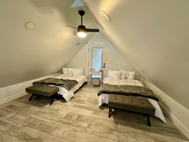 bedroom featuring light hardwood / wood-style floors, vaulted ceiling, and ceiling fan