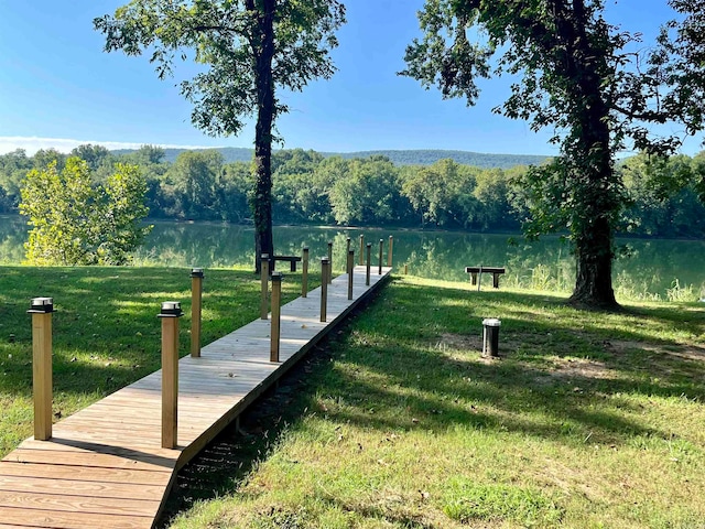 view of dock featuring a water view and a lawn