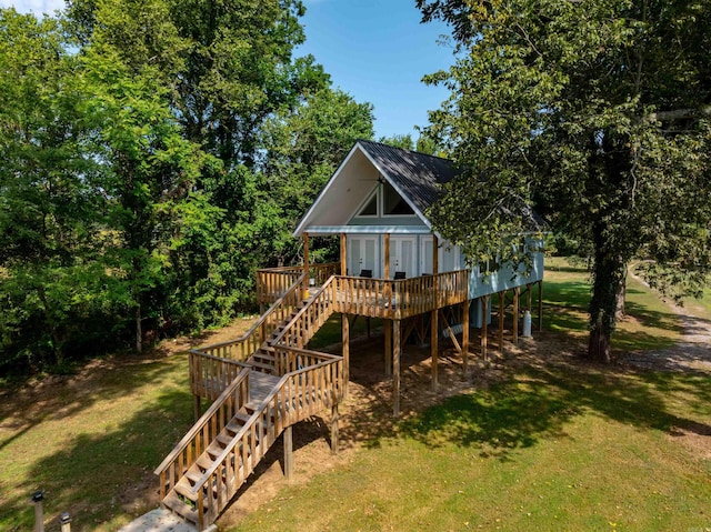 back of property with a wooden deck and a yard