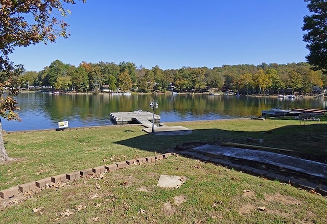 dock area featuring a lawn and a water view