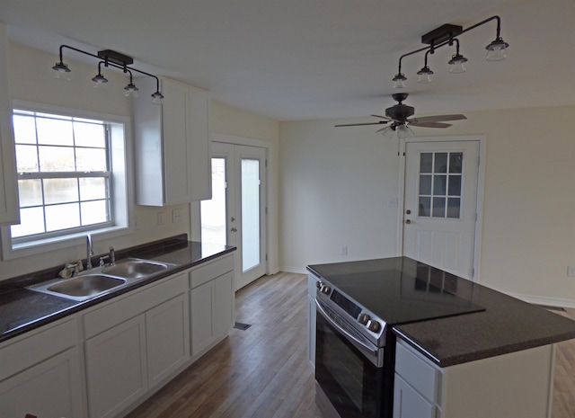 kitchen featuring a sink, dark countertops, and electric stove