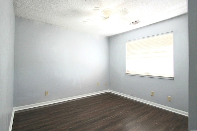 empty room featuring dark wood-type flooring, ceiling fan, and a textured ceiling