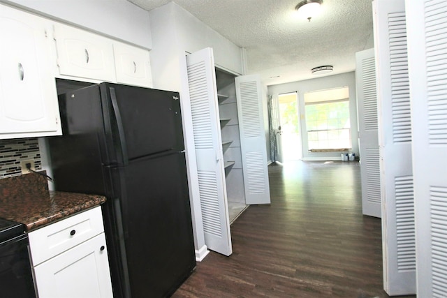 kitchen featuring dark stone counters, a textured ceiling, white cabinets, and dark hardwood / wood-style floors