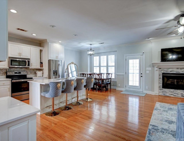 kitchen featuring white cabinets, light hardwood / wood-style flooring, stainless steel appliances, and ceiling fan