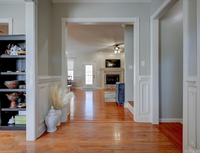 hallway with ornamental molding and light hardwood / wood-style flooring