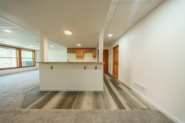 kitchen with hardwood / wood-style floors and a drop ceiling