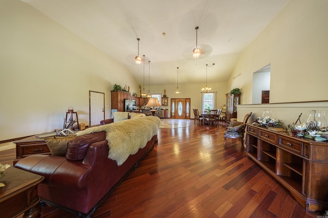 living room with dark hardwood / wood-style flooring, high vaulted ceiling, and an inviting chandelier