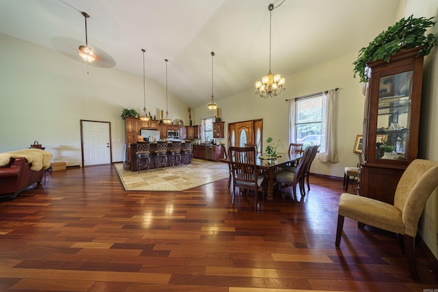 dining area with dark hardwood / wood-style flooring, high vaulted ceiling, and a chandelier