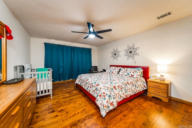 bedroom with ceiling fan, hardwood / wood-style flooring, and a textured ceiling