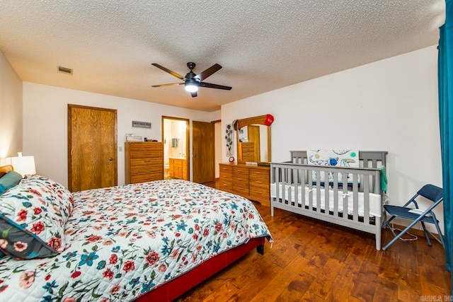 bedroom with a textured ceiling, ceiling fan, and dark hardwood / wood-style flooring