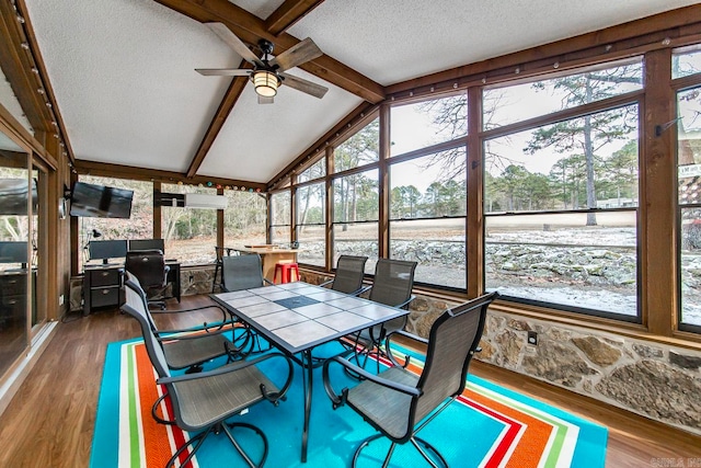 sunroom / solarium with lofted ceiling with beams, plenty of natural light, and ceiling fan