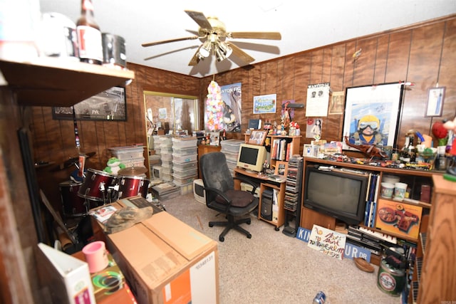 carpeted office featuring ceiling fan and wooden walls