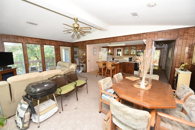 dining area featuring lofted ceiling with beams, ceiling fan, and light colored carpet