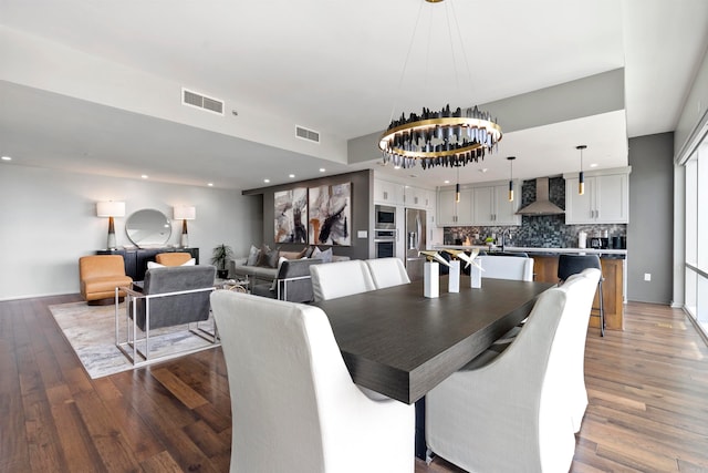 dining area featuring dark wood-type flooring and a notable chandelier