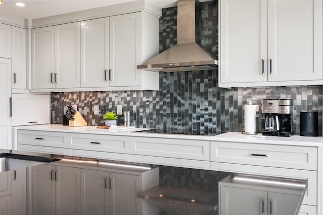 kitchen featuring black electric cooktop, decorative backsplash, and wall chimney range hood