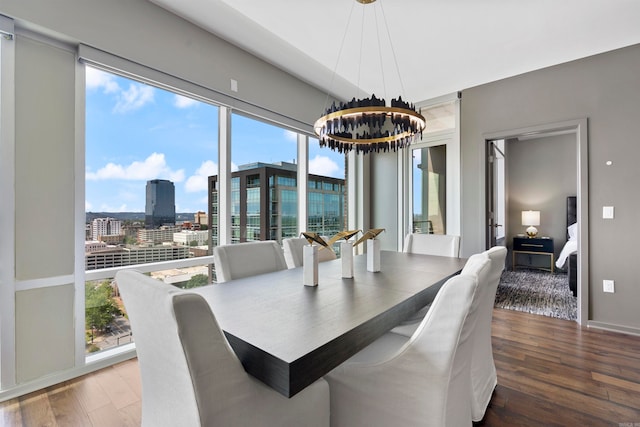 dining space featuring a healthy amount of sunlight, wood-type flooring, and a notable chandelier