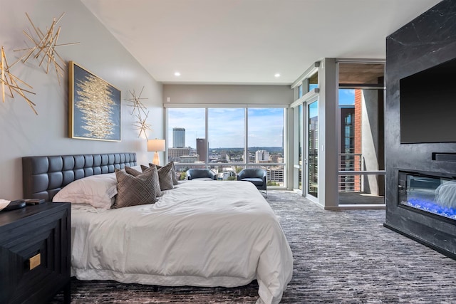 carpeted bedroom with a large fireplace and access to exterior