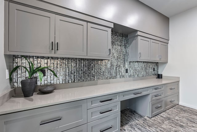 kitchen with built in desk, gray cabinetry, and decorative backsplash