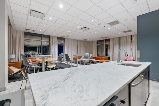 kitchen featuring dishwasher, light tile patterned floors, a paneled ceiling, and sink