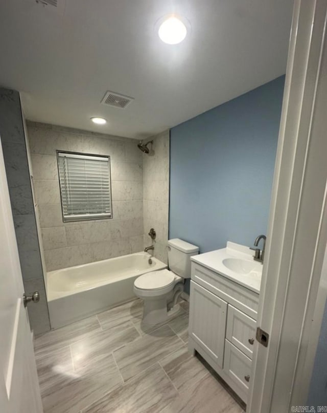 full bathroom featuring vanity, toilet, and tiled shower / bath combo