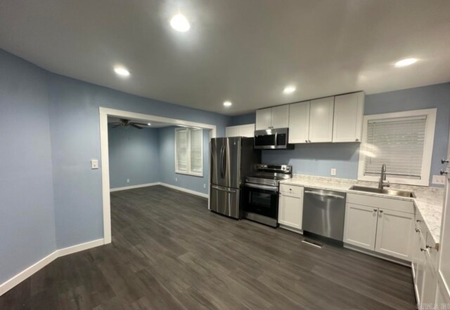 kitchen featuring appliances with stainless steel finishes, sink, white cabinets, and dark hardwood / wood-style floors